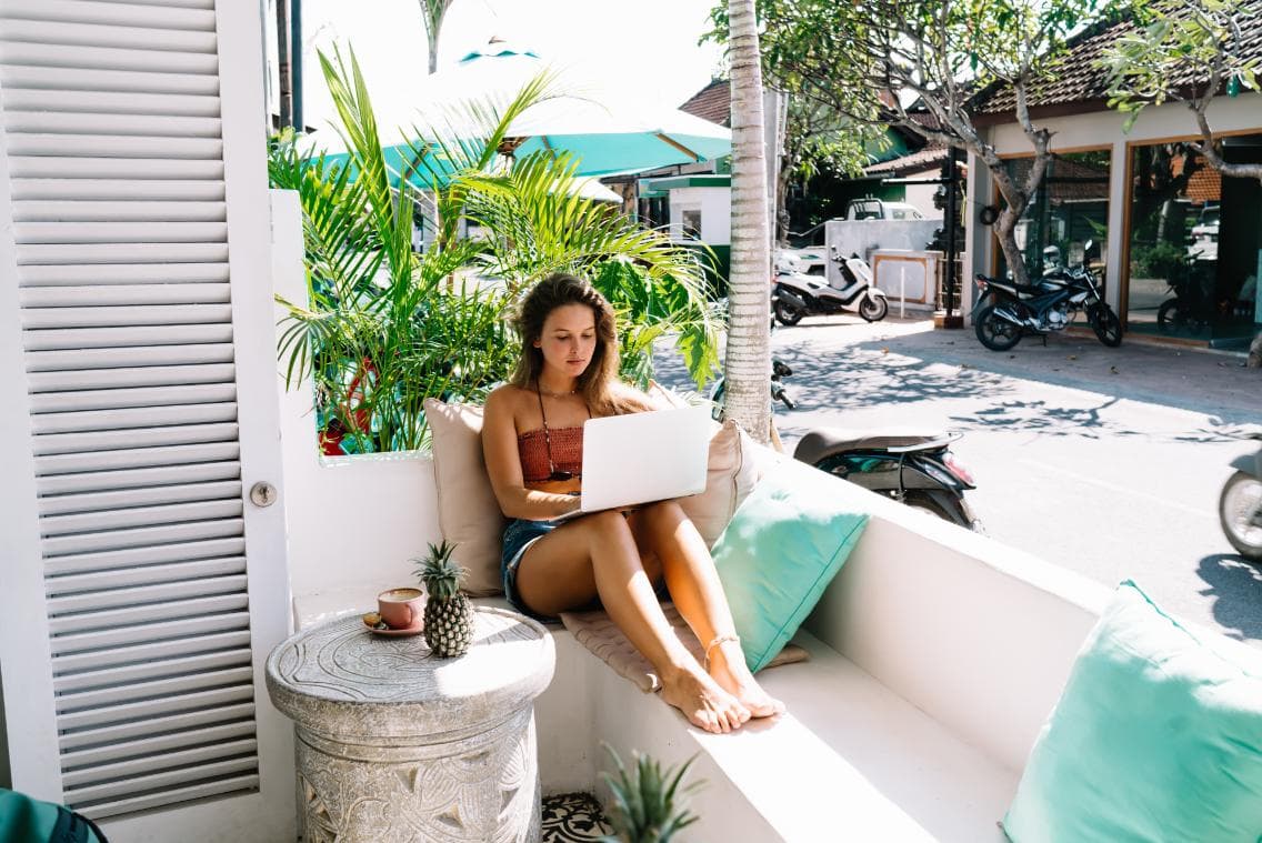 Resort Expert running their travel business from a sunlit poolside